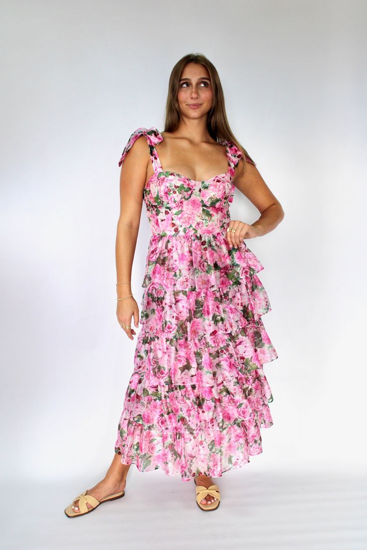 The Olivia Dress is perfect for making a statement with its pink floral print and tiered organza design. The tie straps add a touch of charm while the smocked back ensures a comfortable fit. Elevate your style game with this playful and unique midi dress. Sizing: runs true to size