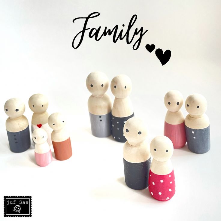 a group of small wooden dolls sitting next to each other on a white surface with the word family written above them