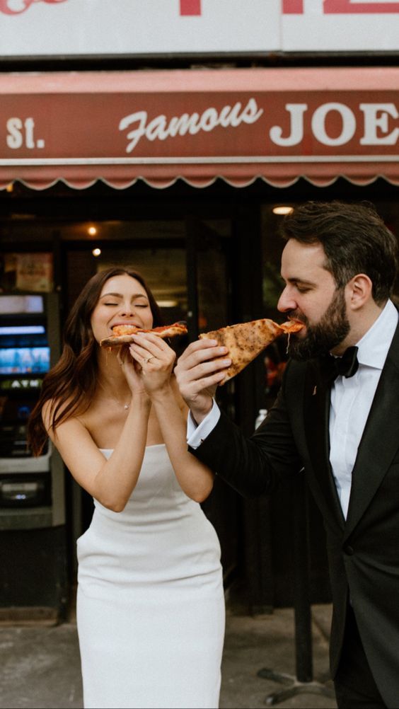 a man and woman eating pizza in front of a restaurant