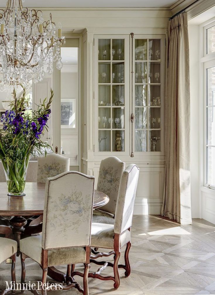 an elegant dining room with chandelier, china cabinet and marble tile flooring