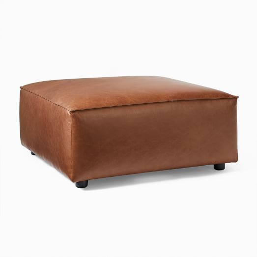 a brown leather ottoman sitting on top of a white floor