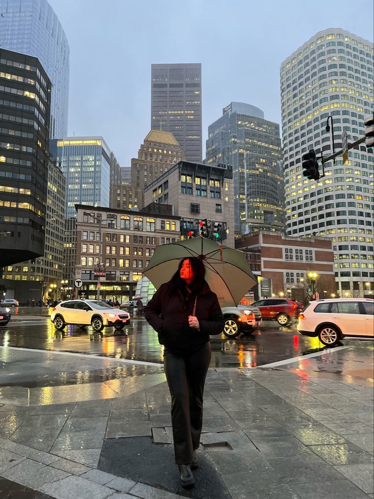 a person with an umbrella is walking in the rain on a city street at night