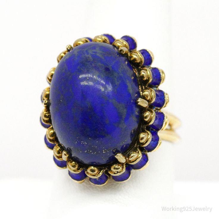 One (1) 14K yellow gold ring is centered with one (1) prong set, lapis lazuli described above. The ring is accented with blue enamel details and measures 25.3mm at the top, rises 15.2mm above the finger, tapering to 3.2 mm wide & 1.2mm thick at the base of the shank. Signed Martine. The ring weighs 16.68 grams. Appraised Value: $3,200.00 Independent Appraisal Included. Pictured boxes are not included. Shipping- Items will arrive carefully packed in a jewelry gift box, wrapped in bubble wrap, and Blue Cabochon Sapphire Ring In 14k Gold, 14k Gold Blue Oval Cabochon Rings, Blue 14k Gold Oval Cabochon Rings, Blue 14k Gold Enamel Ring For Formal Events, Formal Blue Enamel Ring In 14k Gold, Blue 14k Gold Enamel Ring For Formal Occasions, Blue Cabochon 14k Gold Ring, Blue 14k Gold Oval Cabochon Jewelry, 14k Gold Blue Cabochon Rings