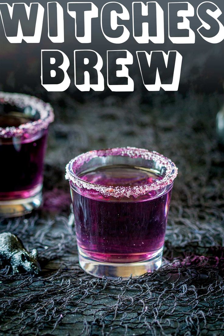 two glasses filled with purple liquid sitting on top of a black cloth covered tablecloth