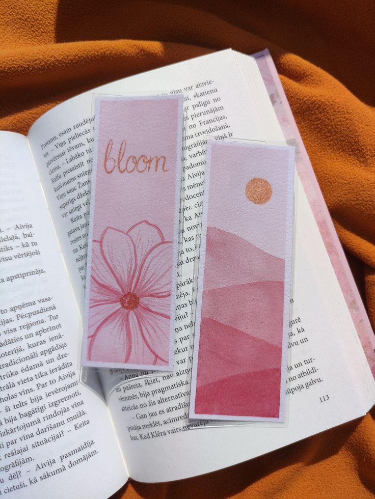 an open book with two pink booksmarks on top of it and the title bloom