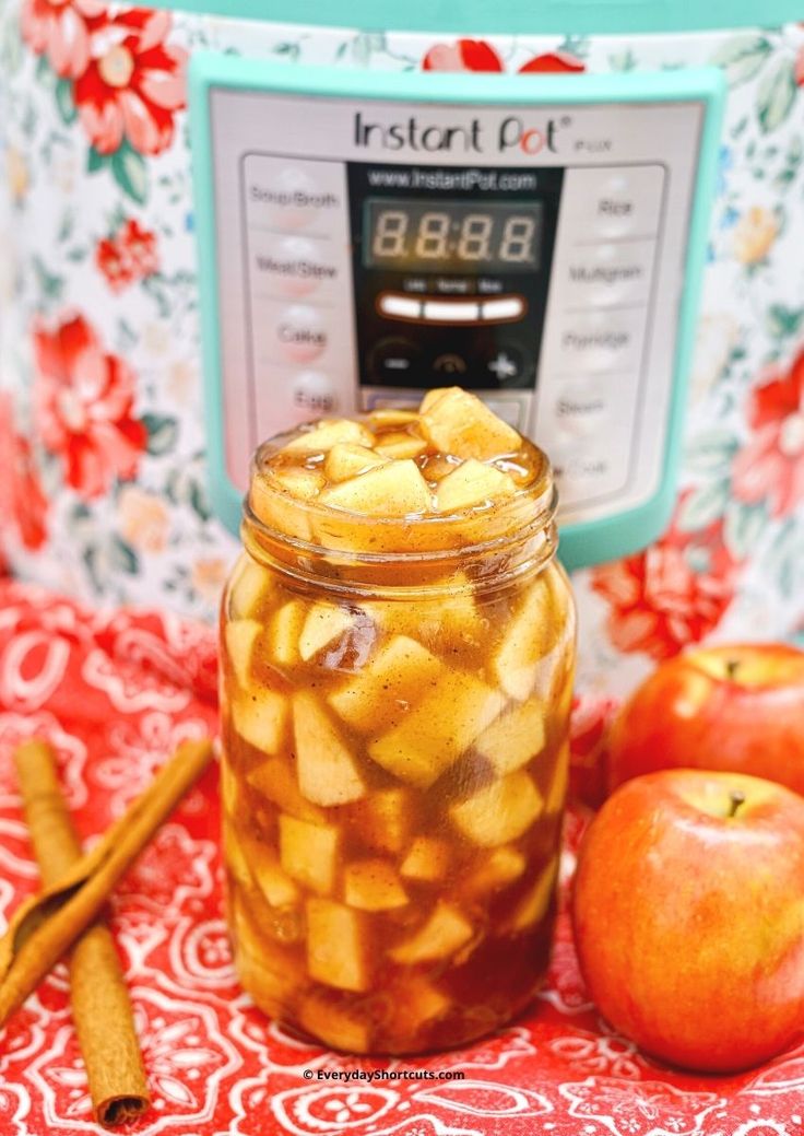 an apple cider with apples and cinnamon sticks in front of the instant pressure cooker