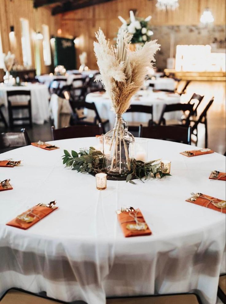 a white table topped with lots of tables covered in white cloths and place settings