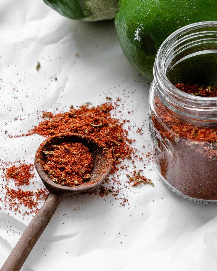 a spoon full of spices sitting next to an avocado and some other ingredients