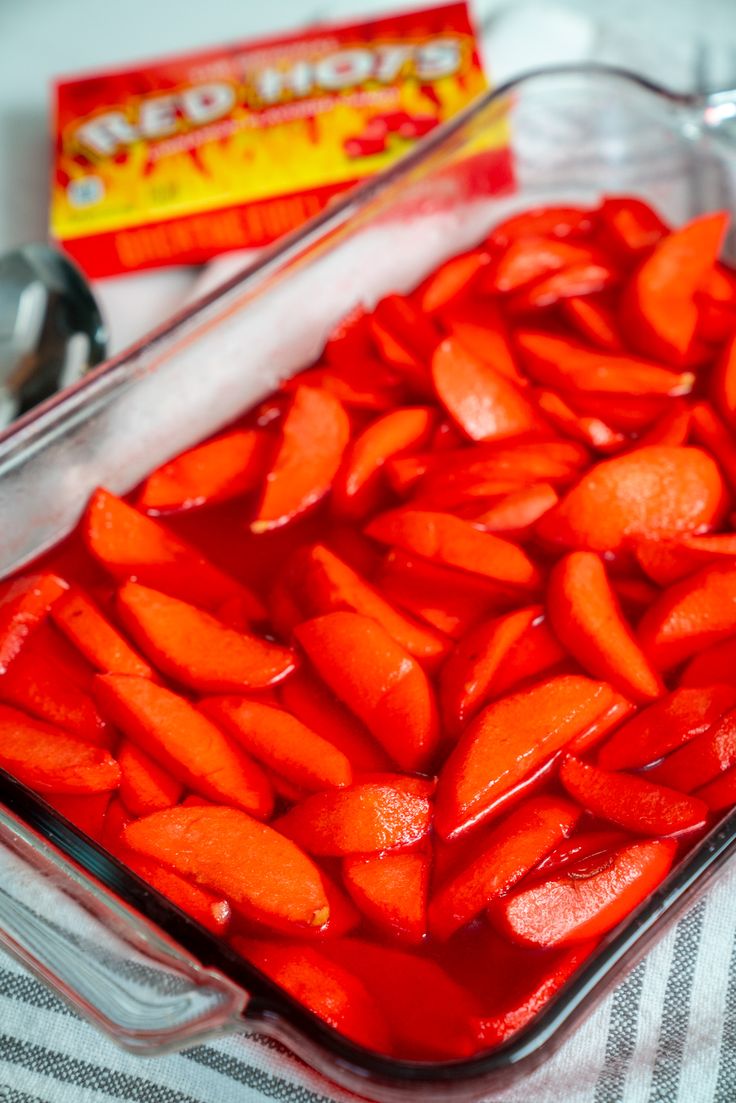 sliced carrots sit in a glass dish next to a candy bar