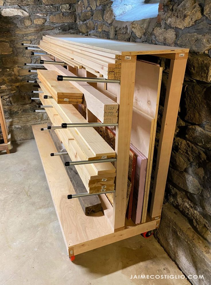 a wooden cabinet with several drawers and shelves in the wall next to a stone wall