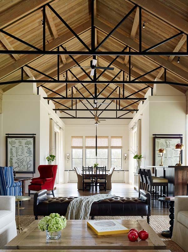 a living room filled with furniture next to a dining room table and two red chairs