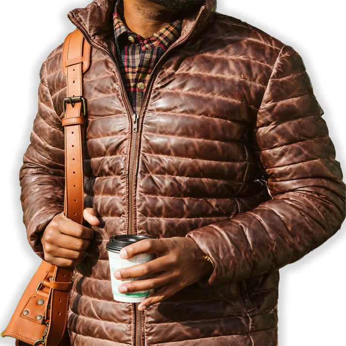 Rugged style meets winter warmth in our Men's Brown Leather Puffer Jacket. Crafted from supple, genuine leather with a rich brown hue, this jacket features quilted puffer insulation for superior heat retention. The classic silhouette is enhanced with a stand-up collar, zippered front, and snug cuffs to keep the cold at bay. Practical side pockets provide storage and hand-warming comfort. Perfect for the fashion-conscious man who doesn't compromise on functionality, this jacket seamlessly transitions from outdoor adventures to city streets. Key features: Premium brown sheepskin leather exterior for durability and style Quilted puffer design for superior insulation Adjustable hem to seal out cold air Multiple pockets for convenient storage Satin lining for a luxurious feel Premium YKK zipper Biker Shirts Women, Spiked Leather Jacket, Mens Leather Blazer, Motorcycle Leather Vest, Racer Jackets, Thigh Bag, Flannel Vest, Varsity Jacket Women, Leather Puffer Jacket