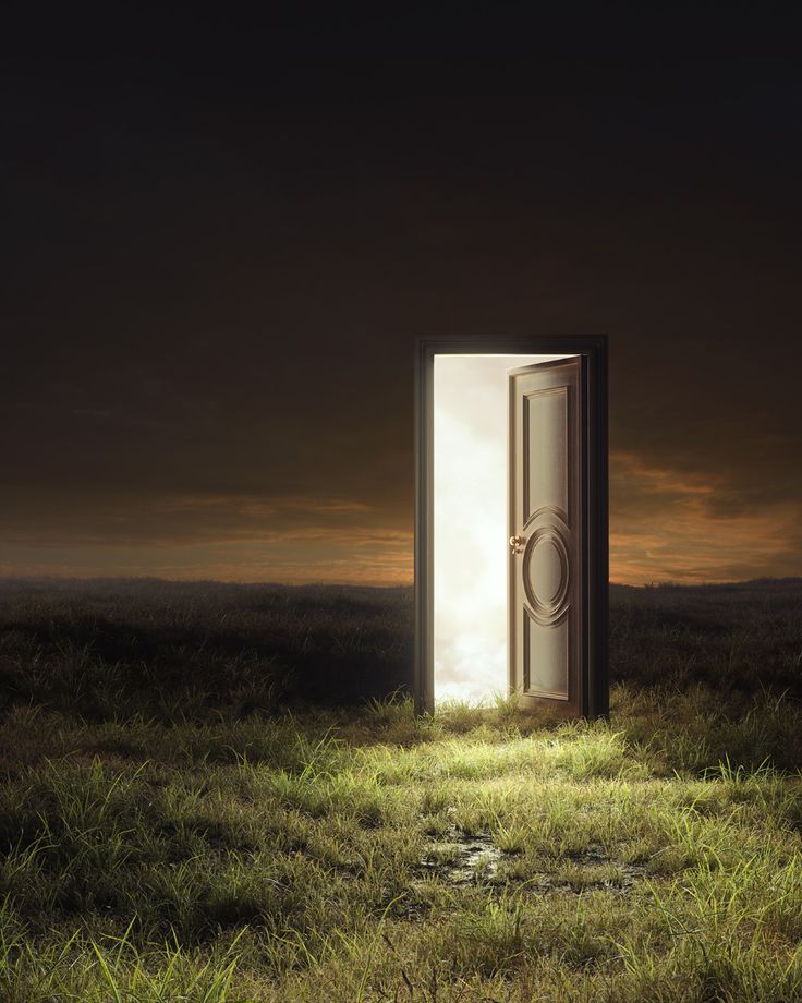 an open door sitting in the middle of a field