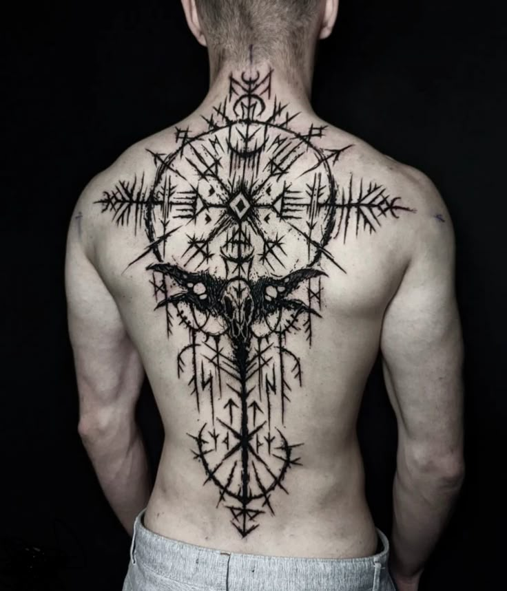 a man's back with an intricate tattoo on it