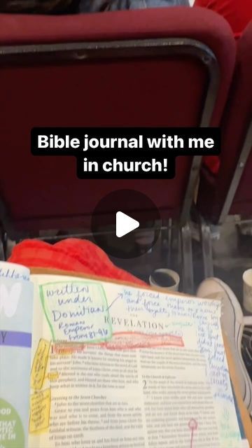 an open bible sitting on top of a table next to a red chair with writing on it