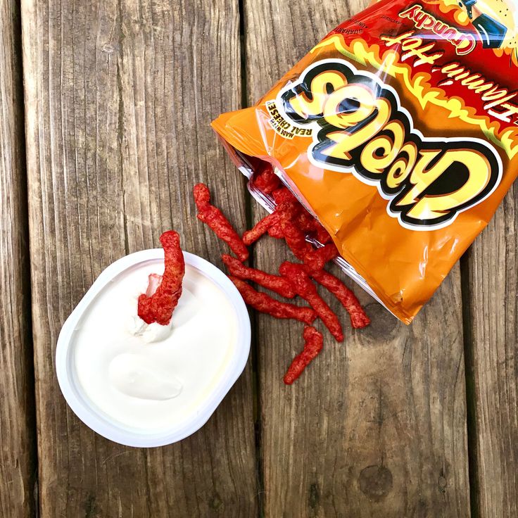 a bag of hotdogs next to a bowl of sour kraut on a wooden table