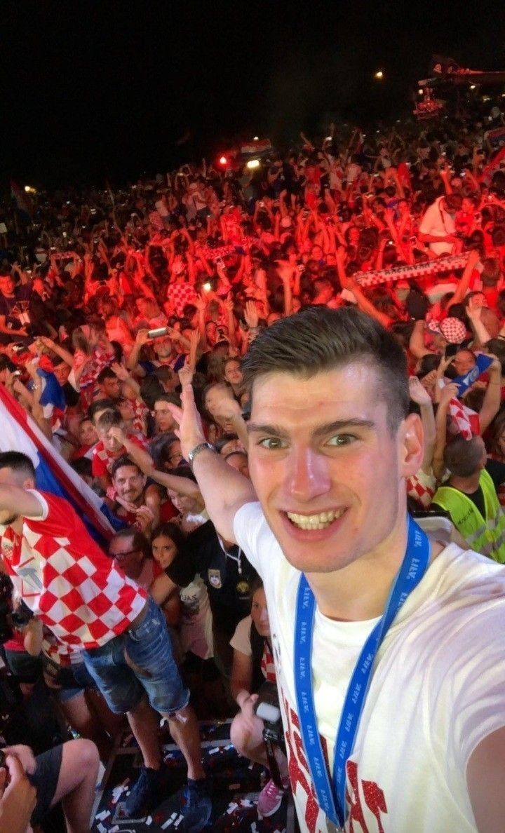 a man standing in front of a crowd at a sporting event with his hands up