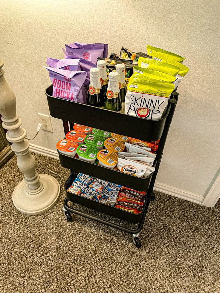 a cart filled with snacks and drinks next to a lamp on top of a carpeted floor