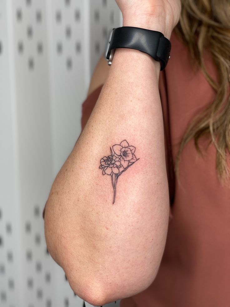 a woman with a flower tattoo on her arm