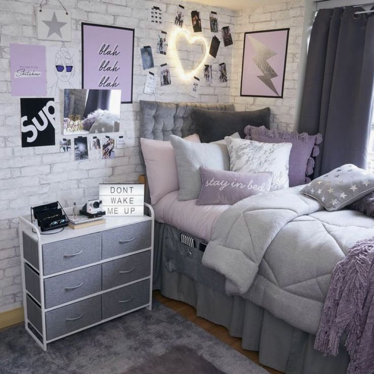 a bed room with a neatly made bed and lots of pictures on the wall above it