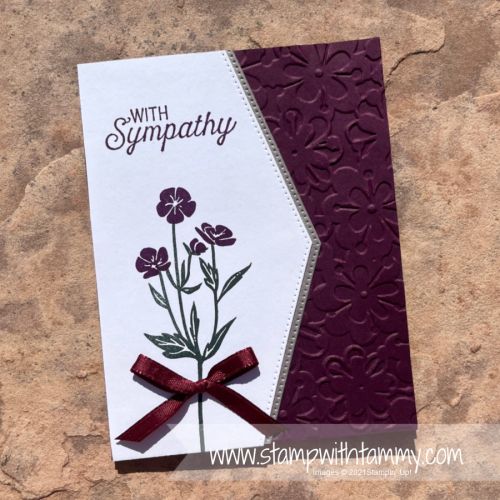 a close up of a card with flowers on it and a ribbon around the edge