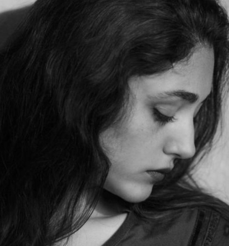 black and white photograph of a woman with long hair looking down at her cell phone