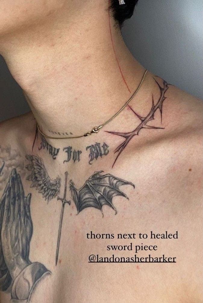 the back of a woman's neck with tattoos on it and words above her chest