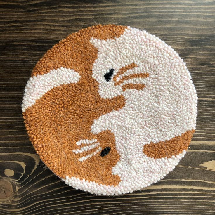 an orange and white cat rug sitting on top of a wooden table