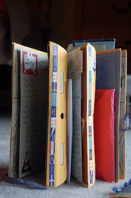 an open book sitting on top of a floor next to a pair of blue scissors