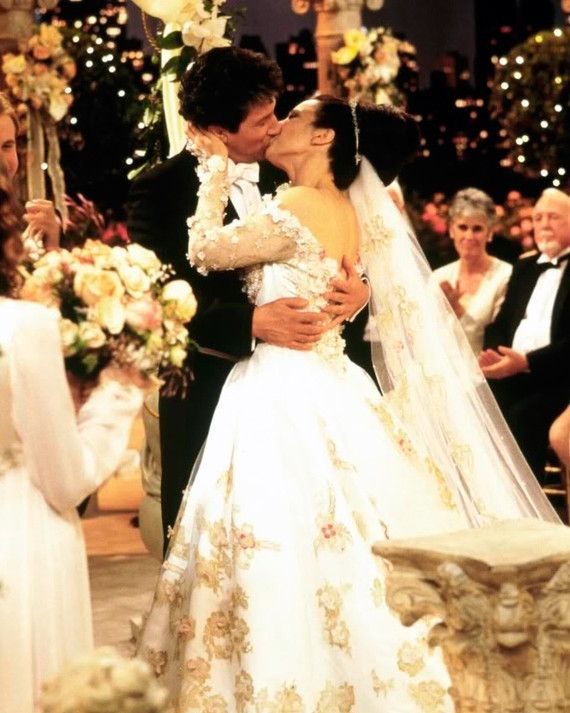 a bride and groom kissing in front of an altar