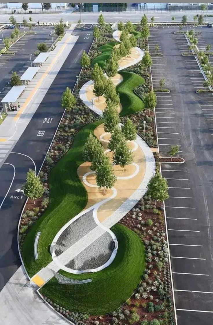 an aerial view of a parking lot with lots of grass and trees on each side