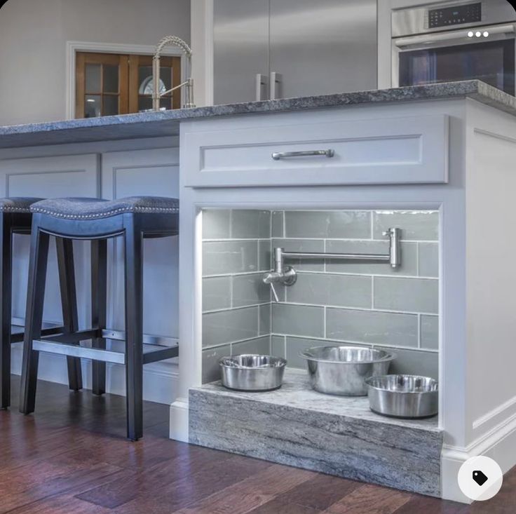 a kitchen with an oven, counter and stools