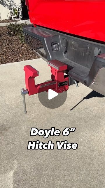 the back end of a red truck parked on top of a cement floor next to a building