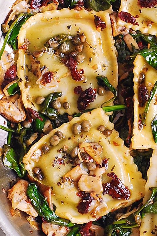 some ravioli with spinach and mushrooms in a white bowl