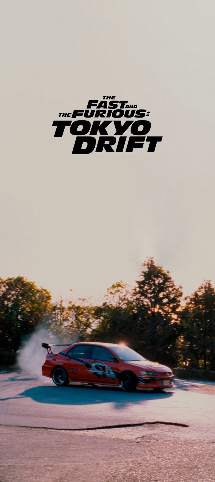 a red car driving down a street next to trees in the background with text that reads, the fast lane tokyo drift