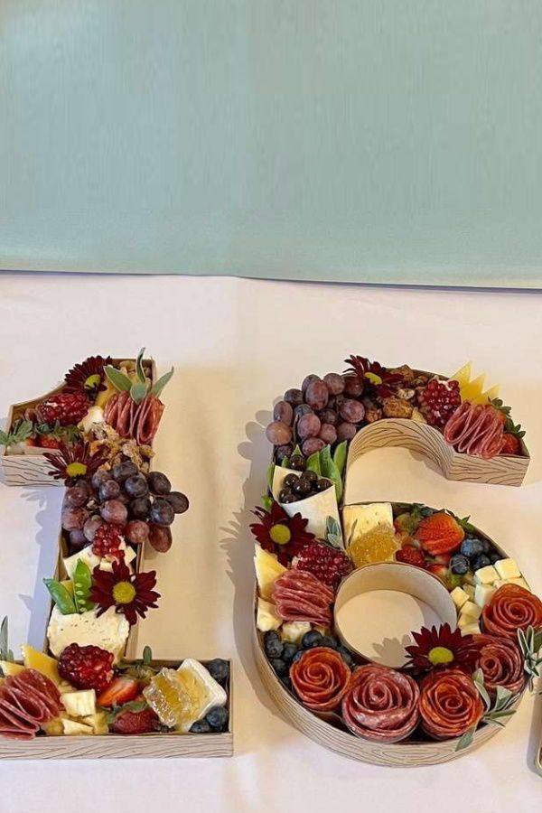 the number 50 made out of fruits and vegetables is displayed in front of a white tablecloth