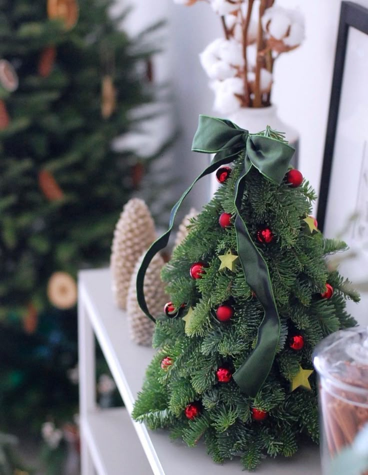 a small christmas tree is sitting on a shelf