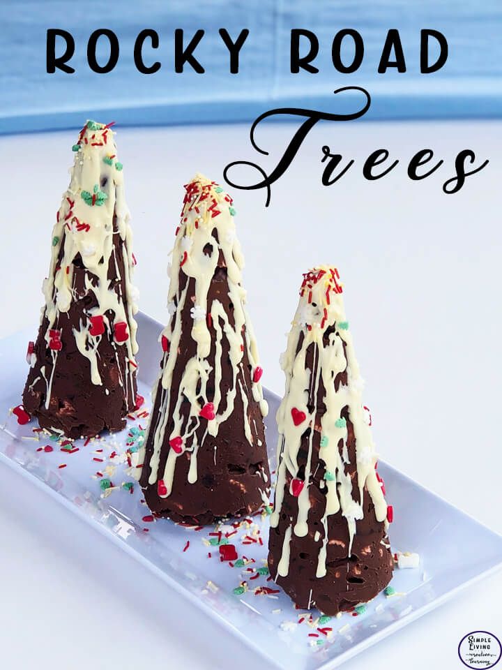 three chocolate trees on a plate with white frosting and sprinkles