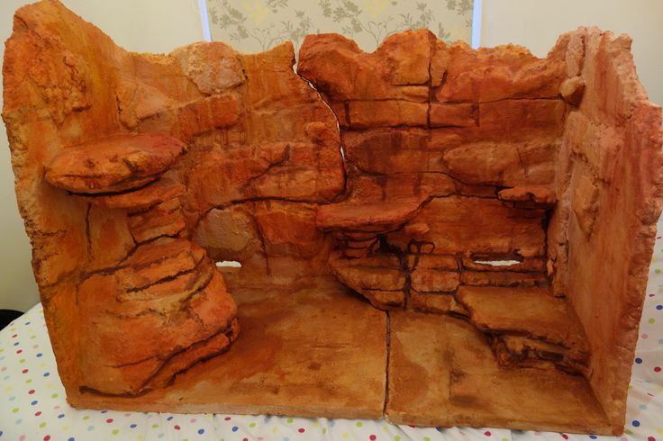 an orange rock formation on a table with polka dot fabric and white wall paper in the background