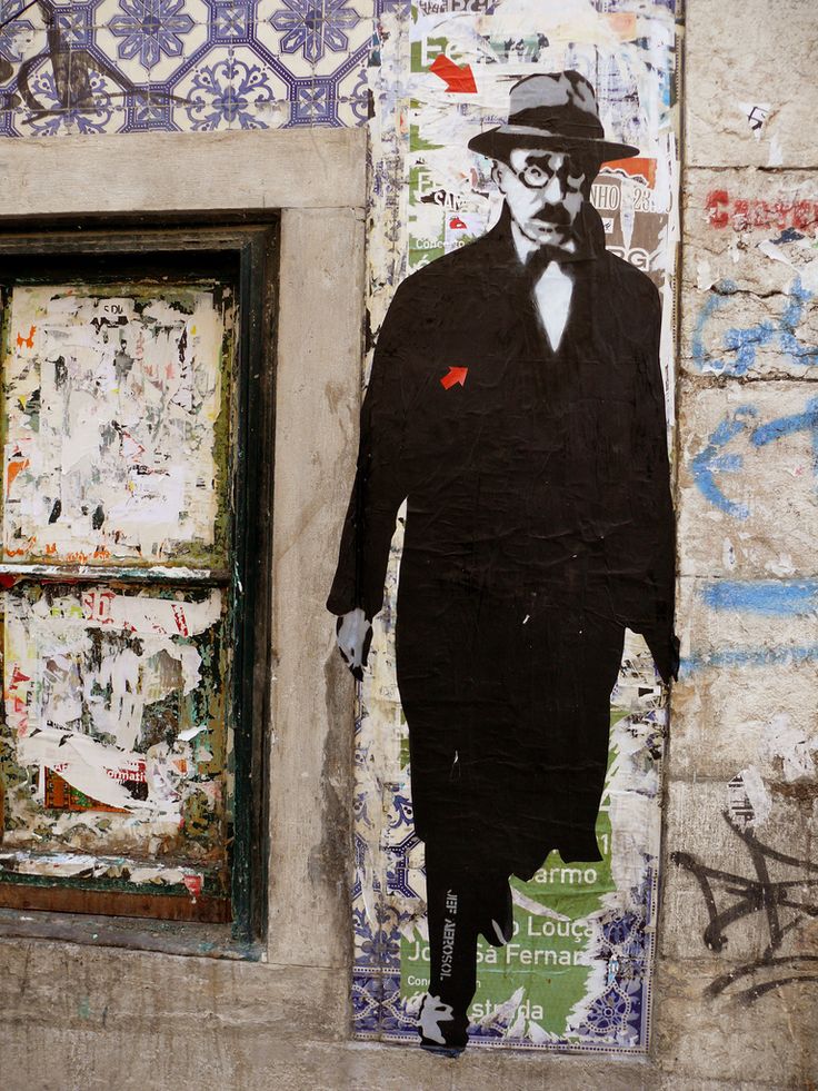 a painting of a man in a suit and hat on the side of a building