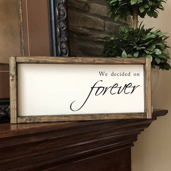 a sign that says we decided on forever sitting on top of a mantle next to a potted plant