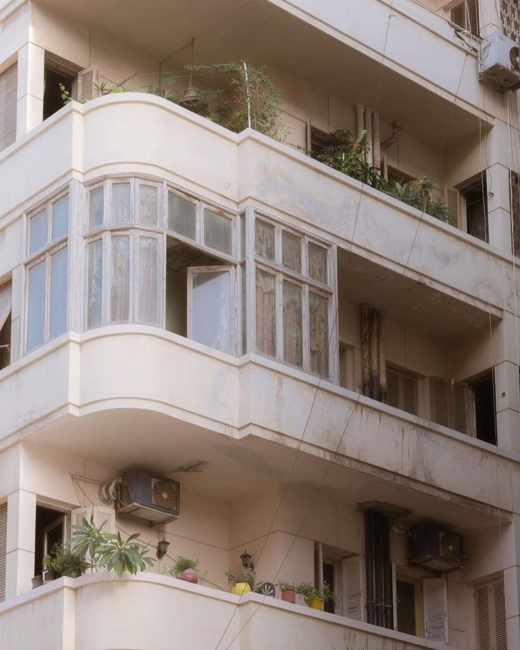 an apartment building with balconies and plants on the balconies