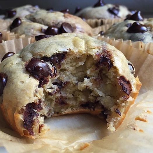 chocolate chip protein banana muffins are cut in half and stacked on top of each other