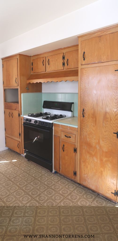 an empty kitchen with wooden cabinets and black stove