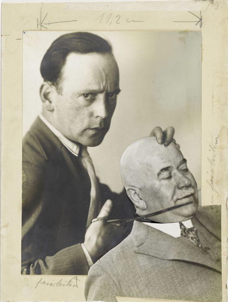 an old black and white photo of a man getting his hair cut by another man