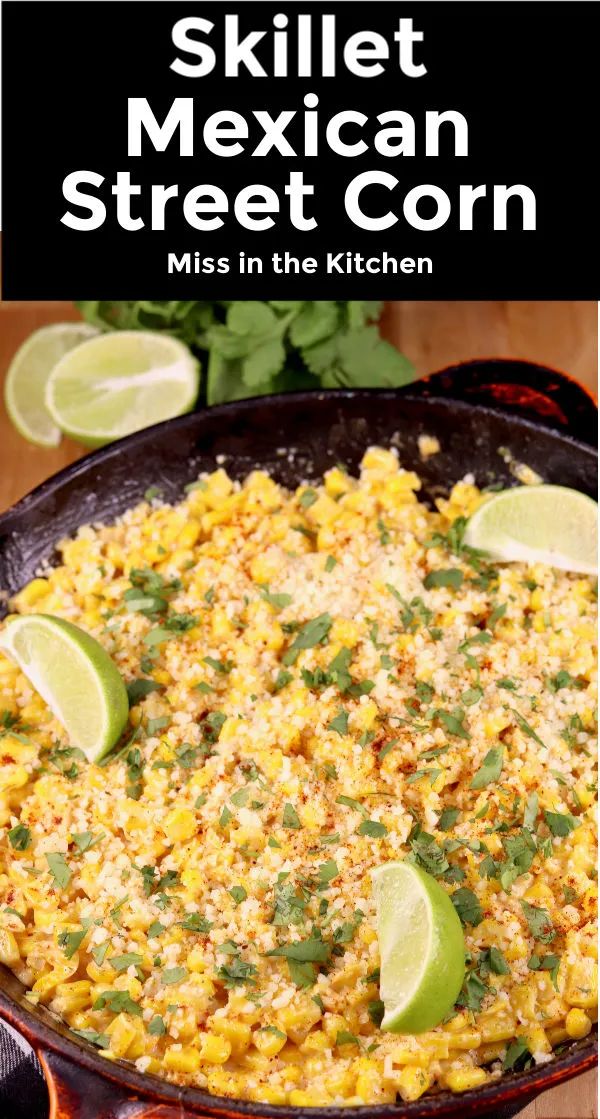 mexican street corn in a skillet with limes and cilantro on the side