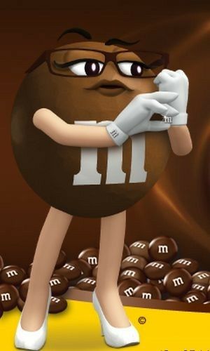 a cartoon character holding a chocolate ball in front of a pile of chocolate balls with the letter m on it