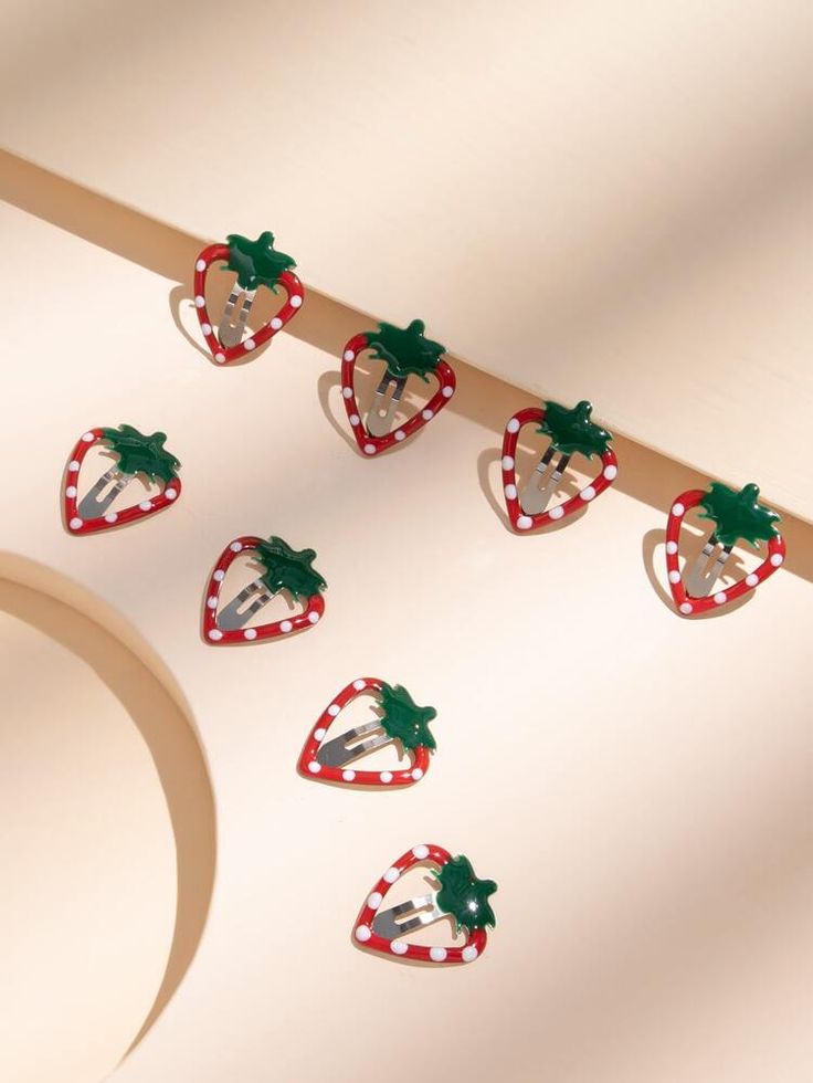 some strawberries are hanging from a wooden stick with christmas decorations on them and one is decorated like a santa hat