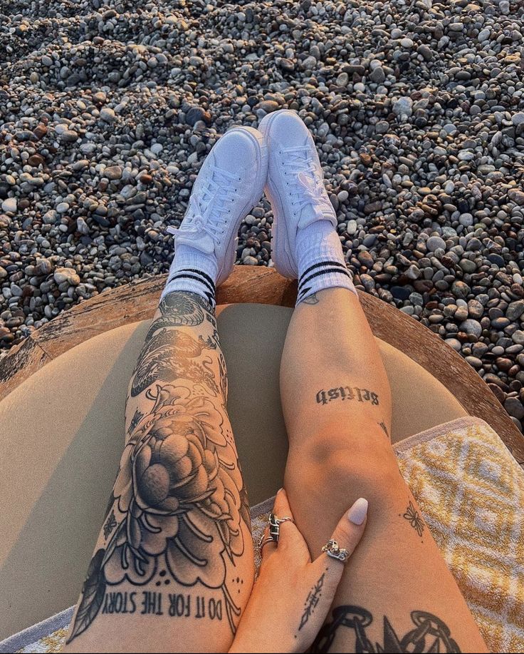 a person with tattoos sitting on a surfboard