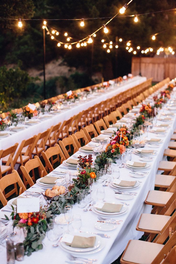 a long table is set up with plates and place settings for dinner guests to enjoy